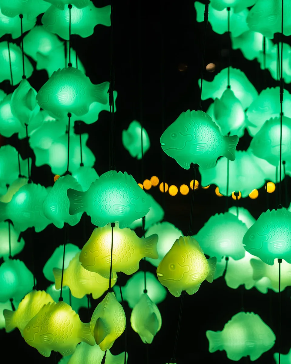 A glowing green and yellow school of fish at Creek Show 2024