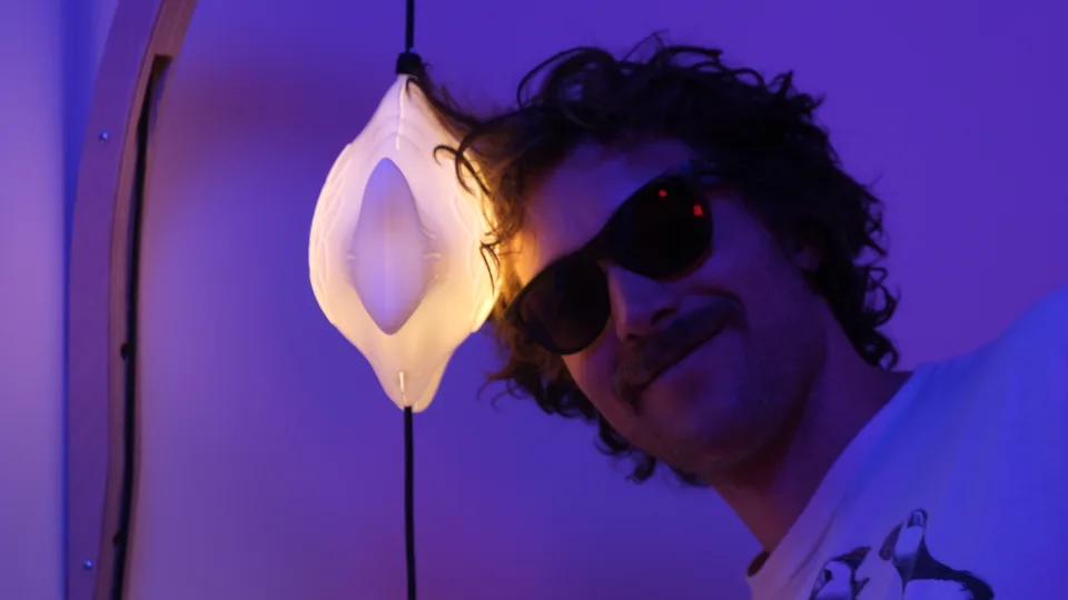 Dan wearing sunglasses beside a glowing fish lamp