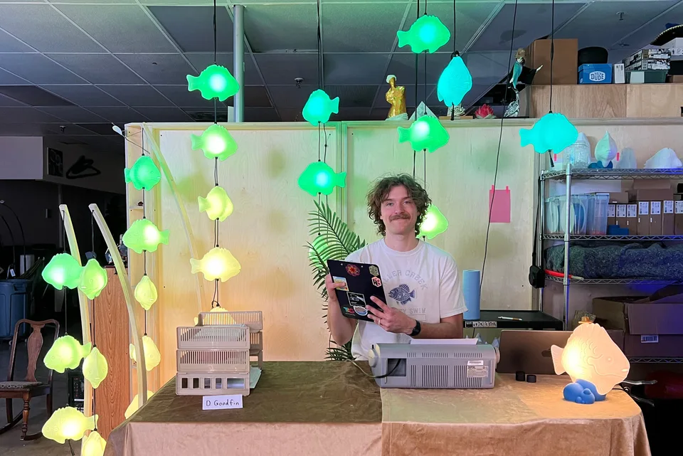 Adoption officer D. Goodfin holding a clipboard at the shop, surrounded by glowing fish lamps